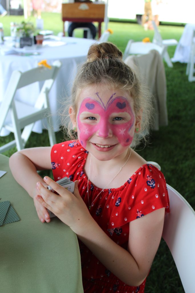 Young girl with a butterfly painted on her face at Croquet on the Green 2019