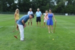 Larry Novik of Bonacio hitting croquet ball while friends look on at Croquet on the Green 2019