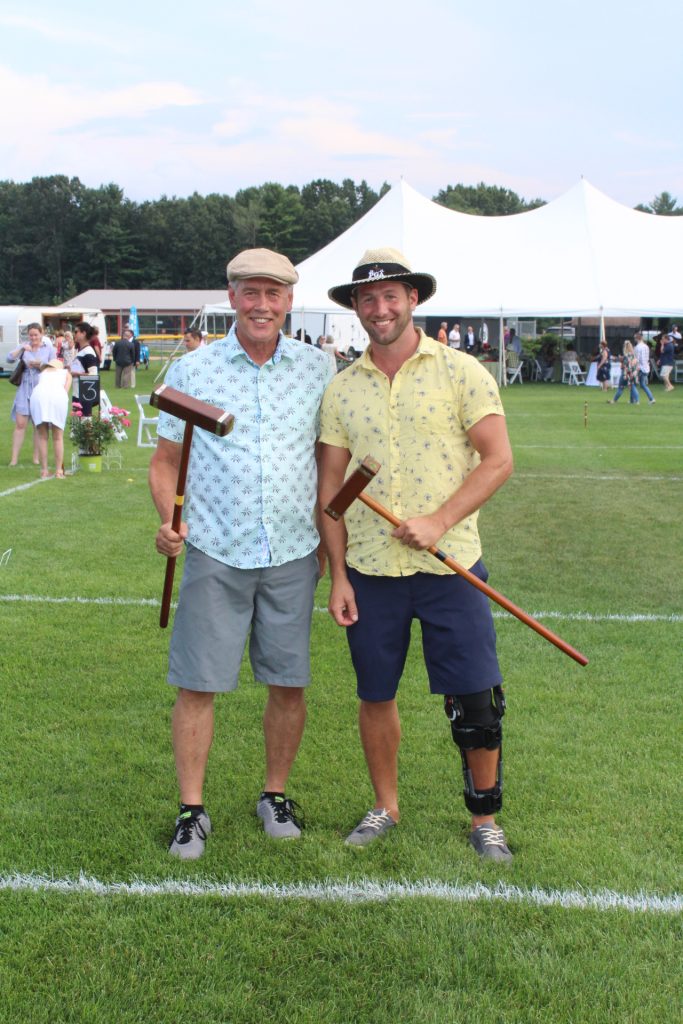 Father and son holding croquet mallets and smiling at Croquet on the Green 2019