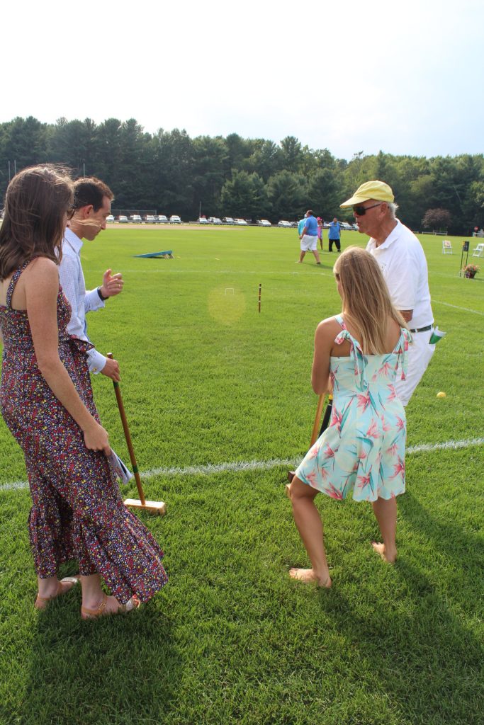 Croquet expert showing three people how to play croquet at Croquet on the Green 2019