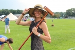 Woman with brimmed hat posing with croquet mallet