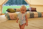 Baby in the glaping tent with a tiara on at Croquet on the Green 2019