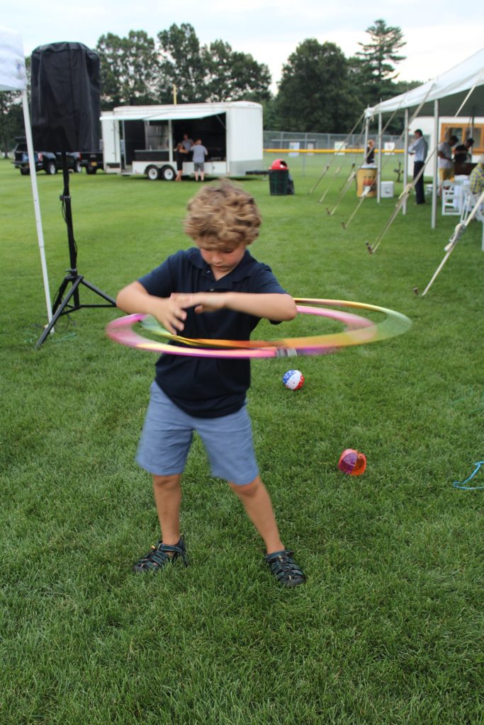 Young boy hula hooping with two hula hoops at Croquet on the Green 2019