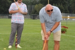 Bob Wiltsie bent over lining up his croquet shot while teammate stands behind him holding mallet at Croquet on the Green 2019