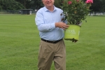 Scott Hartung holding a big pot of pink flowers at Croquet on the Green 2019