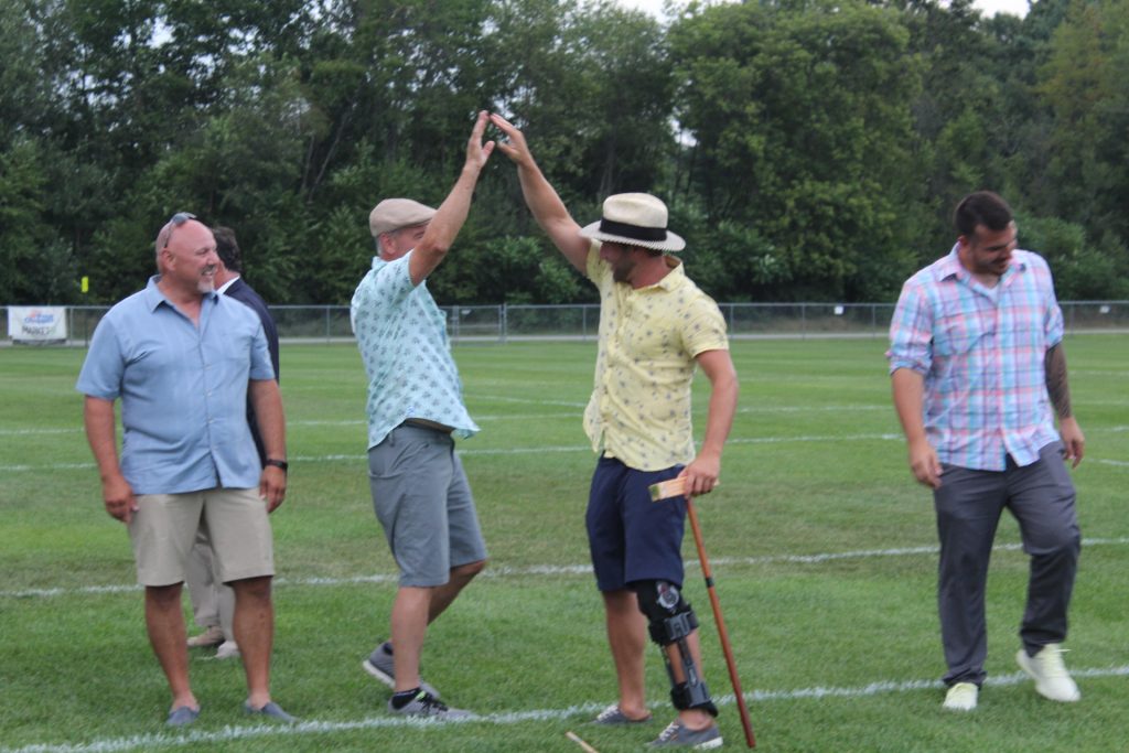 Two men high fiving on croquet field at Croquet on the Green 2019
