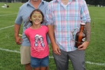 Two men and a young girl with dragon face paint on smiling together at Croquet on the Green 2019