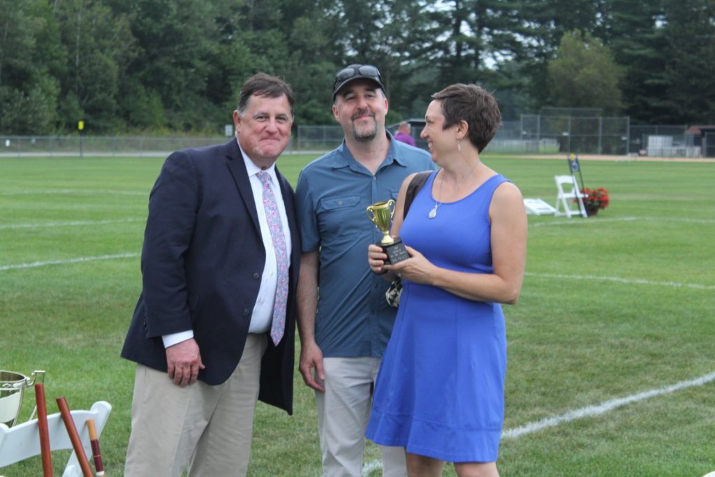 Third place winners, Beth and Larry Novik holding their trophy and smiling with Chris Lyons next to them at Croquet on the Green 2019