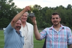 2nd place winners of croquet, Bob Wiltsie and Matt Stevens holding their trophy in the air with Walt Adams looking on in the background at Croquet on the Green 2019
