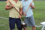 Croquet tournament winners, Brett and Brett Jr. Armstrong, holding mallets sticking out of big trophy at Croquet on the Green 2019