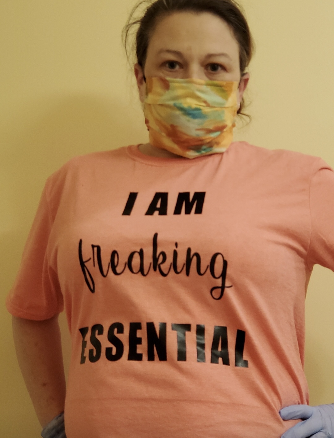 Stacie wearing a face mask and t-shirt that says "I am freaking essential"