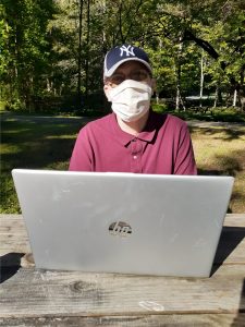 Man sitting in front of a laptop outdoors