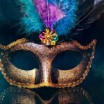 gold mask with purple blue and teal feathers