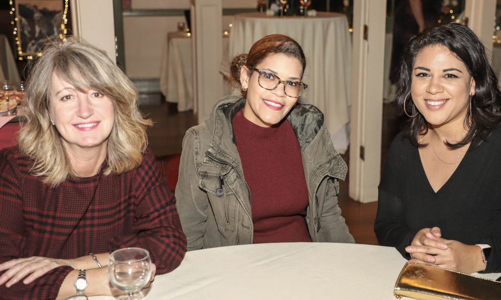Three women sitting at a table at AIM Services Vin Le Soir 2021