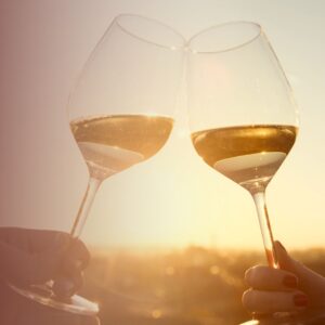 wine glass cheers over sunset