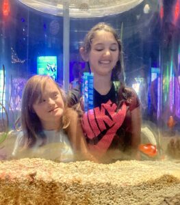two young girls looking in a fish tank
