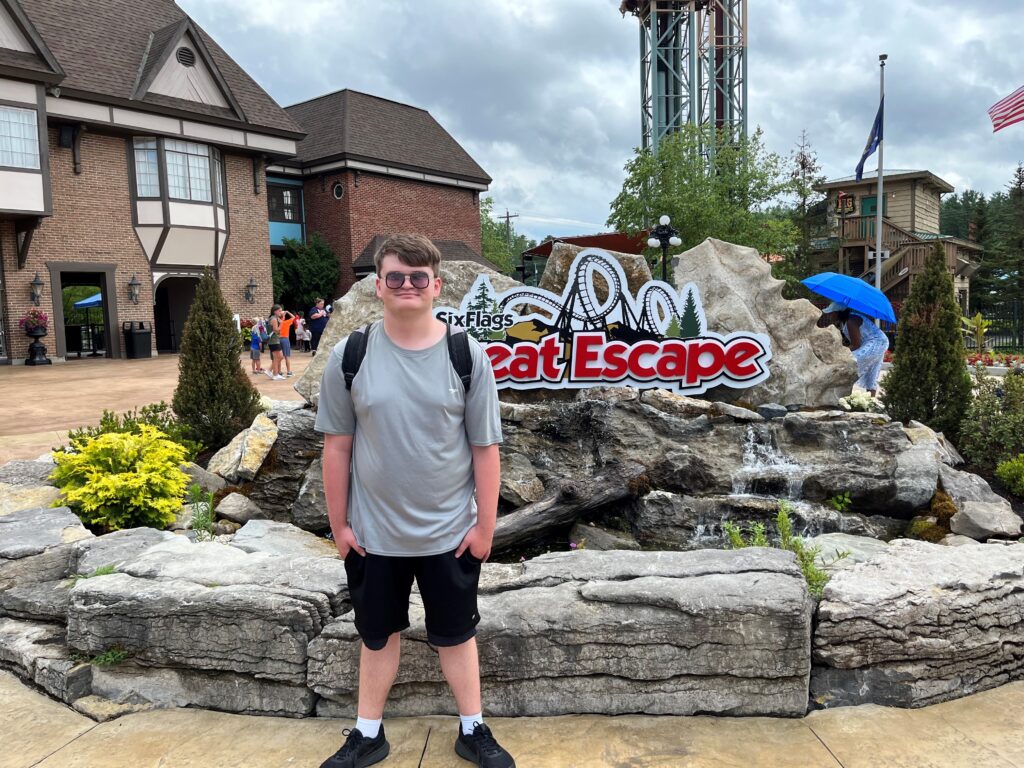 young man standing in front of great escape sign