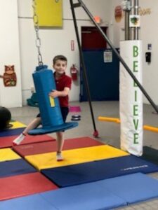 boy on swinging gym equipment