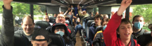 People sitting on a bus cheering
