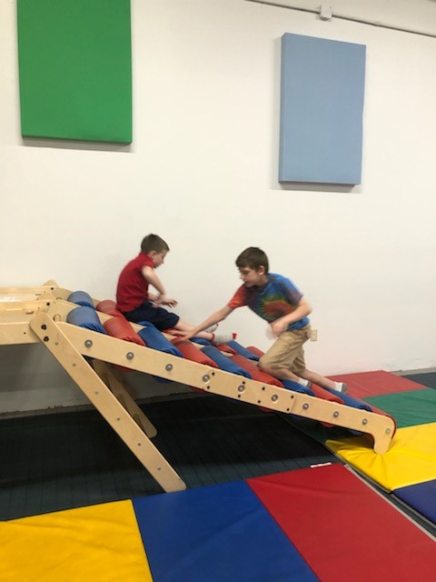 two kids playing on a colorful ramp