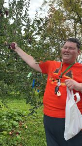man holding apple off of apple tree